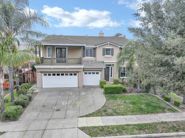 View of front of home featuring a balcony, an attached garage, stucco siding, concrete driveway, and a tiled roof