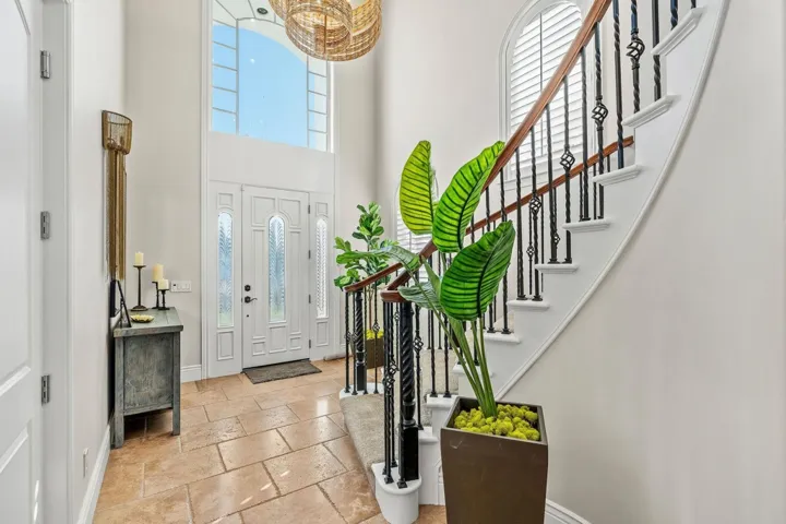Foyer entrance with plenty of natural light, a high ceiling, stone tile floors, and stairs