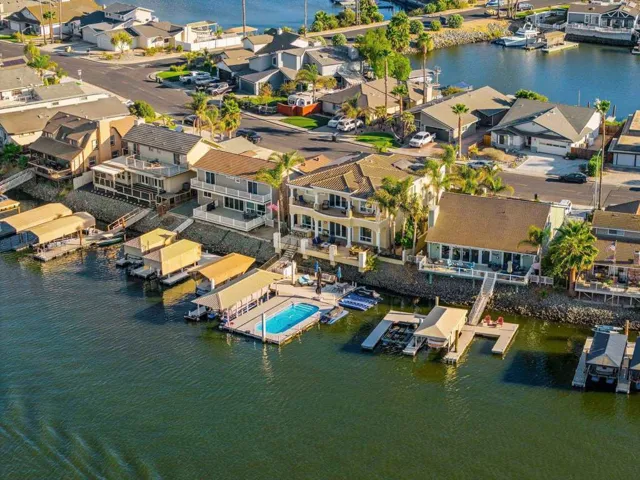 Aerial perspective of suburban area featuring a nearby body of water