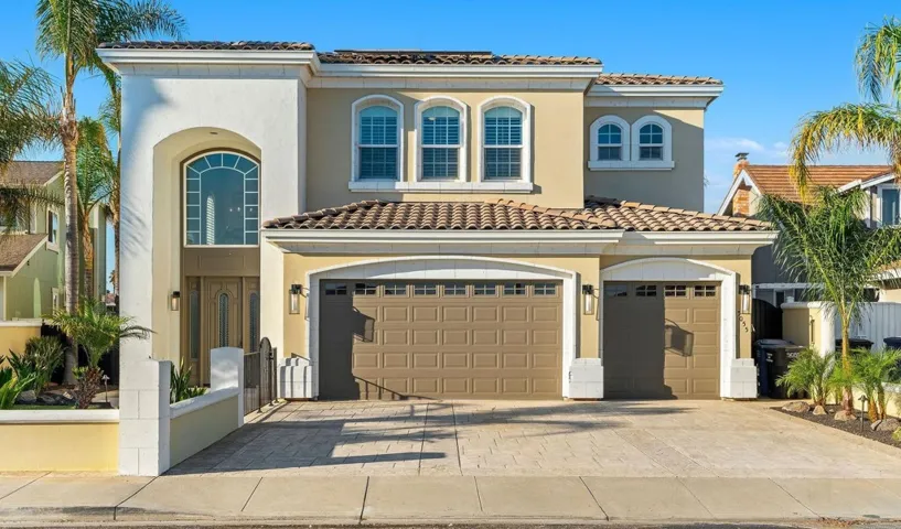 Mediterranean / spanish-style home featuring a tiled roof, decorative driveway, stucco siding, and a garage