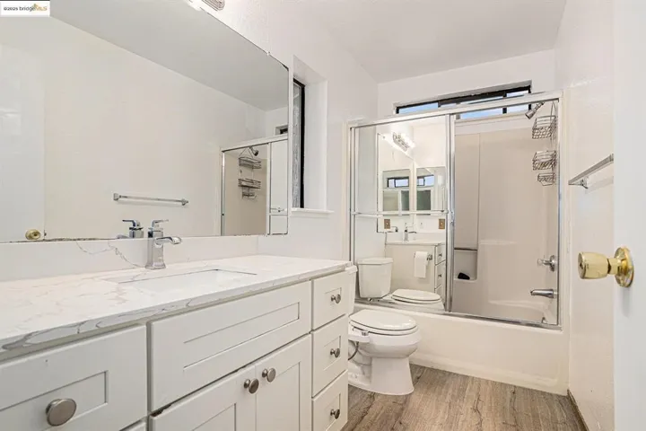 Full bathroom featuring shower / bath combination with glass door, light wood finished floors, and vanity