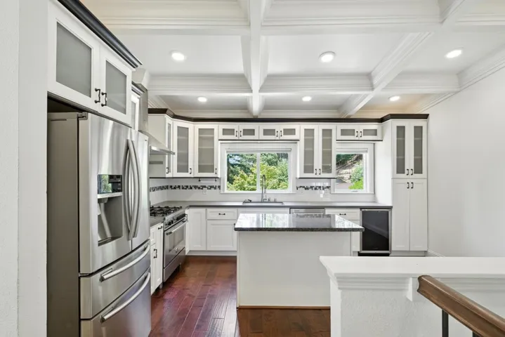 Kitchen featuring appliances with stainless steel finishes, white cabinets, coffered ceiling, recessed lighting, and beamed ceiling