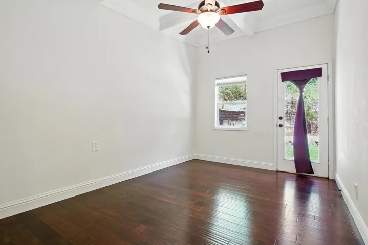 Foyer featuring dark wood-type flooring, crown molding, beam ceiling, ceiling fan, and coffered ceiling