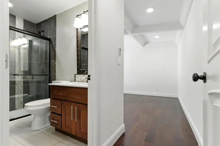 Full bath with vanity, a shower stall, beam ceiling, dark wood-type flooring, and recessed lighting