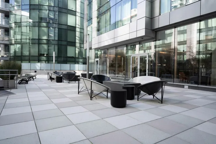 Outdoor seating area featuring a fireplace and heated seating, conveniently located just outside the clubhouse.