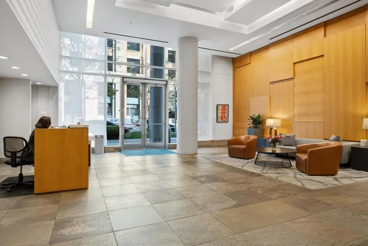 Light-filled tower lobby featuring high ceilings, a wall of windows, and wood accents