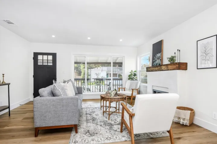 Living room with a fireplace, light wood finished floors, and recessed lighting