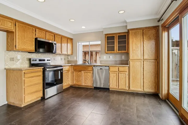 Kitchen featuring stainless steel appliances, tasteful backsplash, plenty of natural light, ornamental molding, and recessed lighting