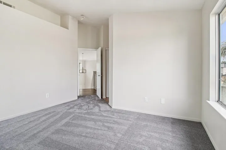 Unfurnished room featuring carpet flooring and healthy amount of natural light