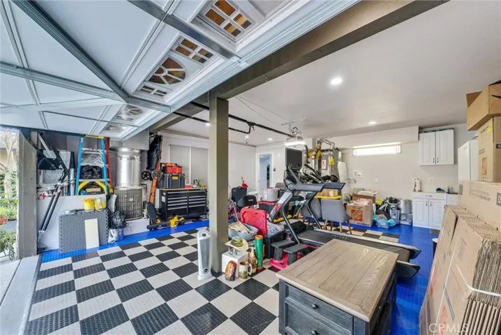 New flooring in the garage with access to a laundry area featuring new cabinet.