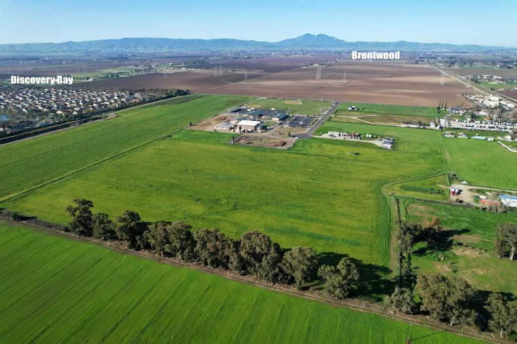Overview of rural landscape featuring a mountain backdrop and extensive farmland