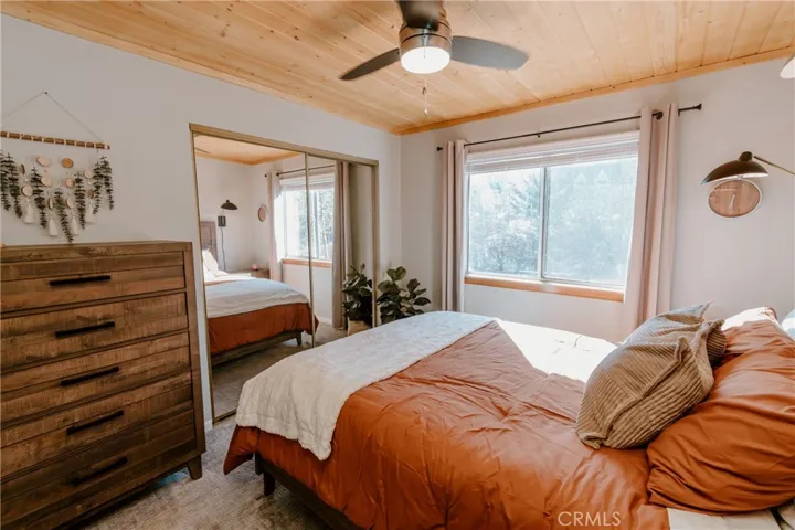 2nd bedroom with dresser, wood-beamed ceiling and and well-appointed