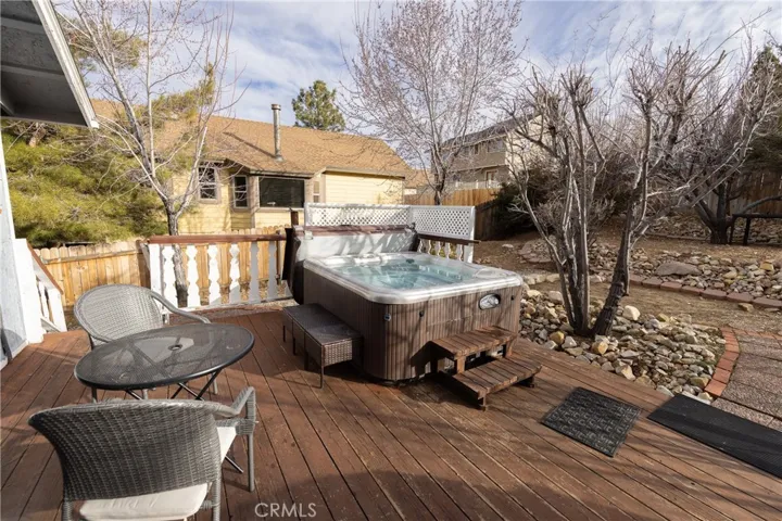 The backyard features a spacious deck with a hot tub, creating an inviting outdoor retreat.