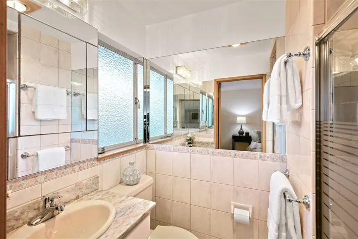 Ensuite bathroom with vanity, tile walls, and a shower with shower door