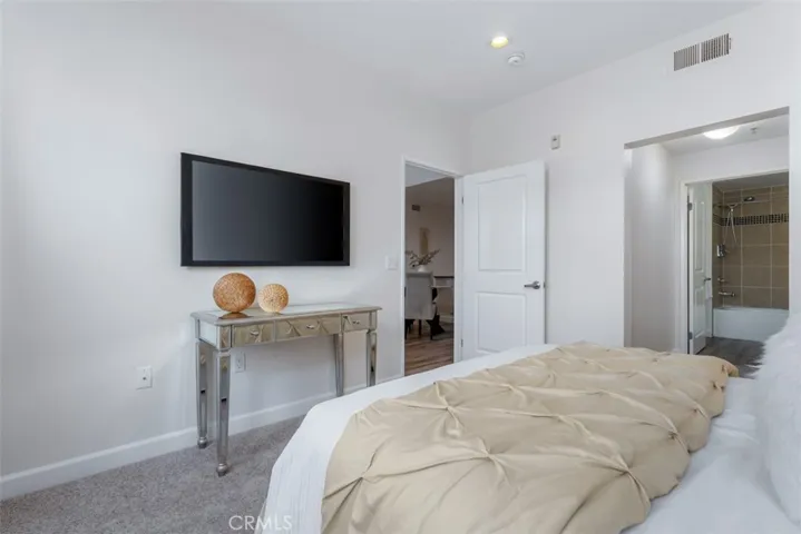 Primary bedroom with new carpet flooring and recessed lighting