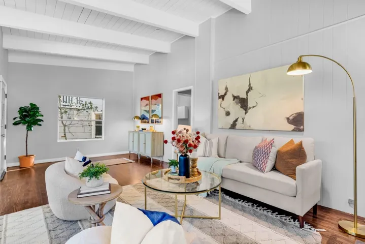 Living area featuring wood finished floors and beam ceiling