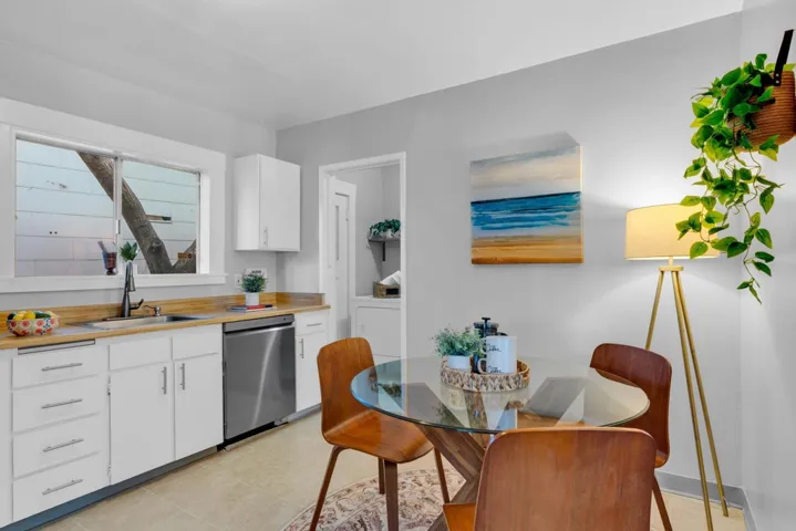 Kitchen featuring white cabinetry, dishwasher, light tile patterned flooring, and butcher block countertops