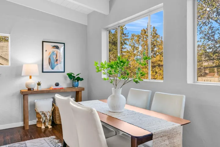 Dining space featuring beam ceiling and dark wood finished floors