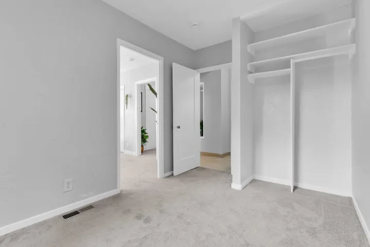 Unfurnished bedroom featuring baseboards and light carpet