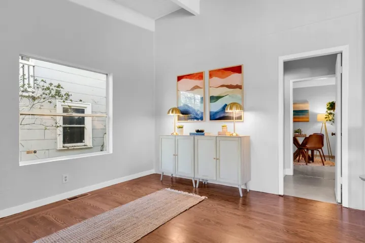 Sitting room featuring beamed ceiling and wood finished floors