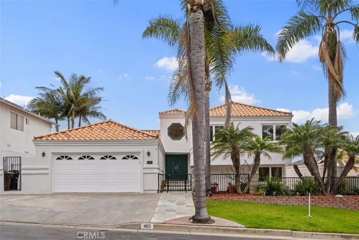 Front of Home with a nice green front lawn and beautiful palm trees. Gardener included