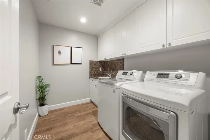Larger laundry room with cabinet and sink