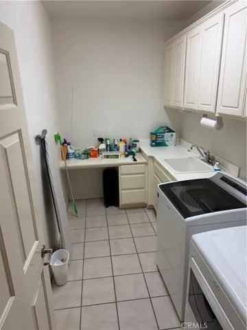 Large laundry room with sink and storage.