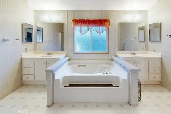 promary bathroom with 2 sinks and a soaking tub