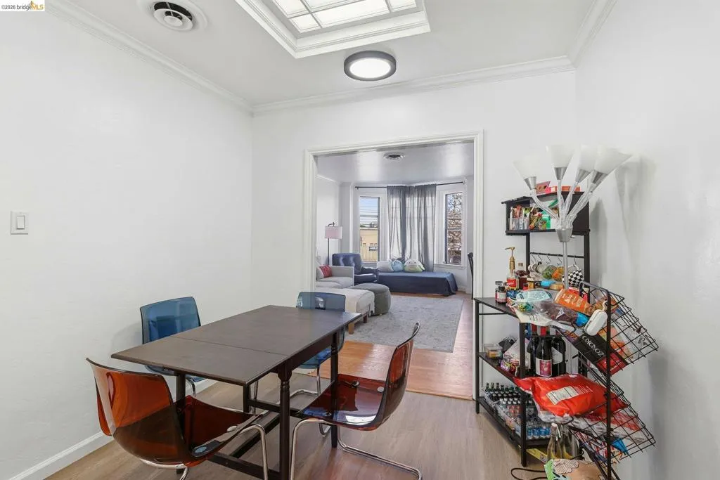 Dining area with light wood-style floors and crown molding