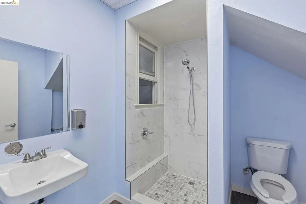 Bathroom with toilet and a marble finish shower