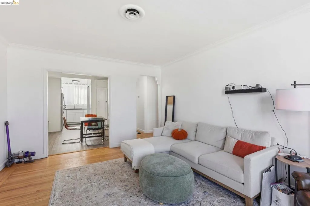 Living room with light wood-style floors and ornamental molding