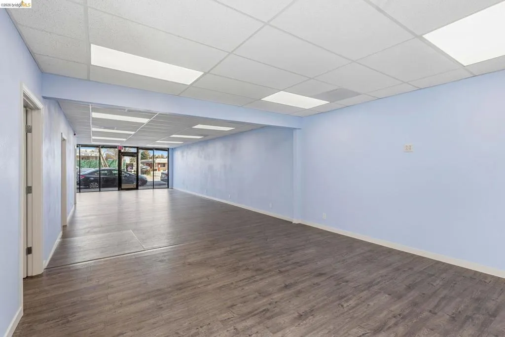Empty room featuring a drop ceiling and dark wood finished floors