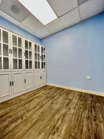 Spare room with a drop ceiling and wood finished floors