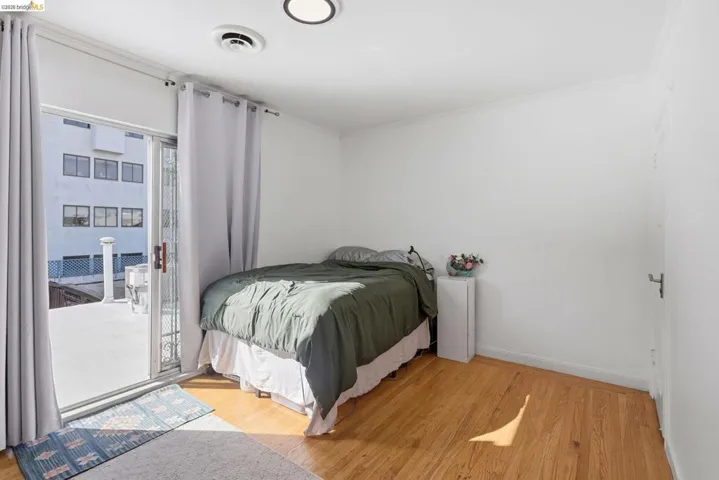 Bedroom featuring light wood finished floors, access to exterior, and ornamental molding