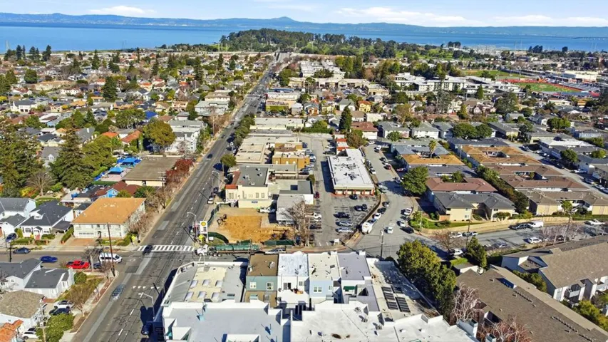 Aerial overview of property's location featuring a water and mountain view and nearby suburban area