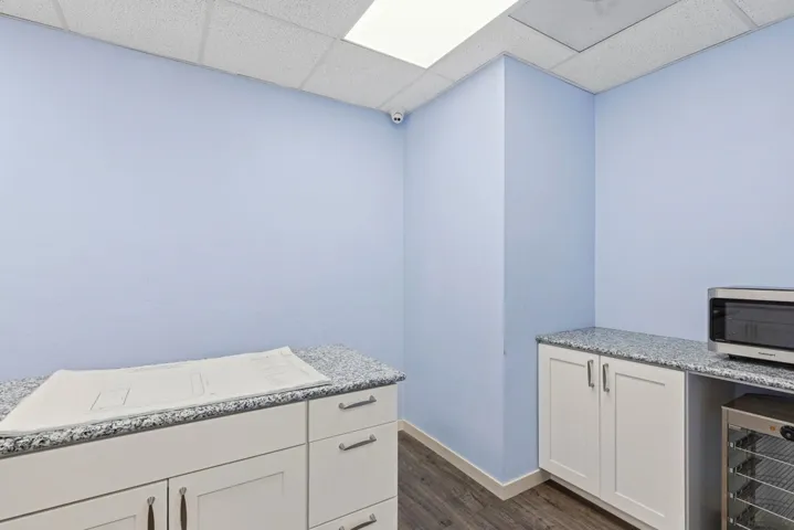 Bathroom with a drop ceiling, wine cooler, vanity, and dark wood-style floors