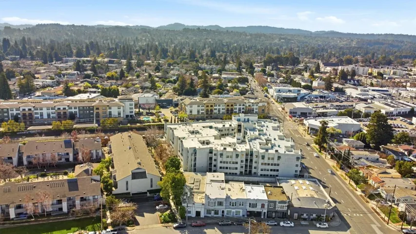 Aerial view of property and surrounding area with a mountain backdrop and a forest