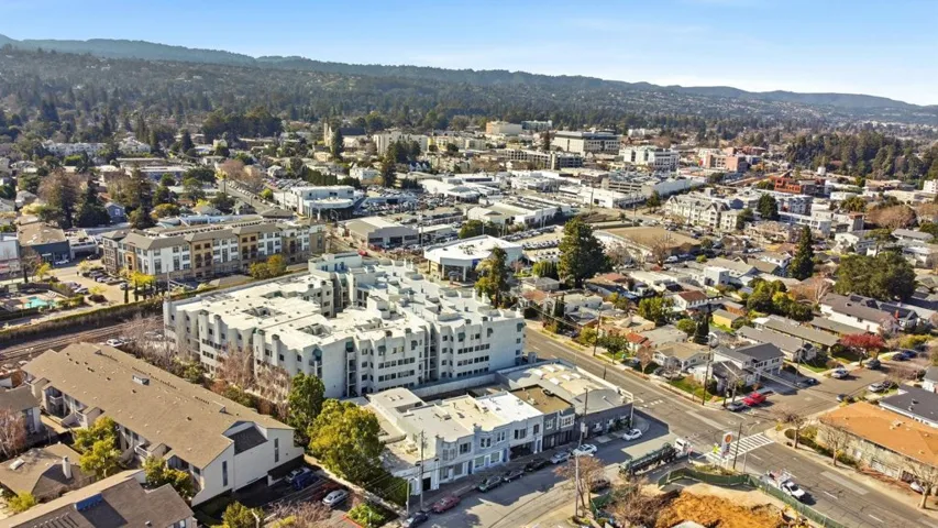 Aerial view of property and surrounding area featuring a mountain backdrop