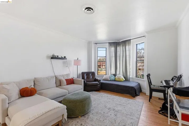 Living area featuring light wood finished floors and ornamental molding