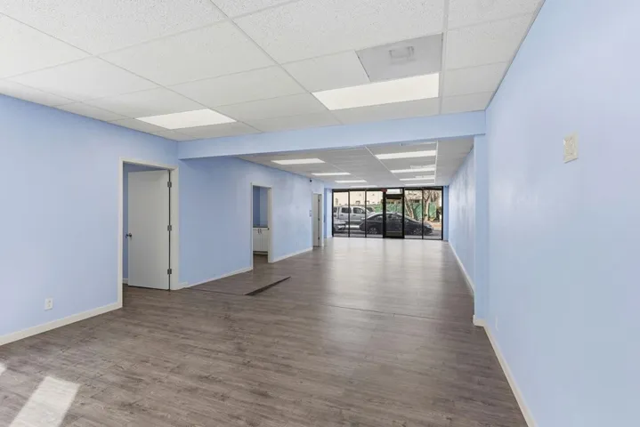 Unfurnished room with a paneled ceiling and wood finished floors