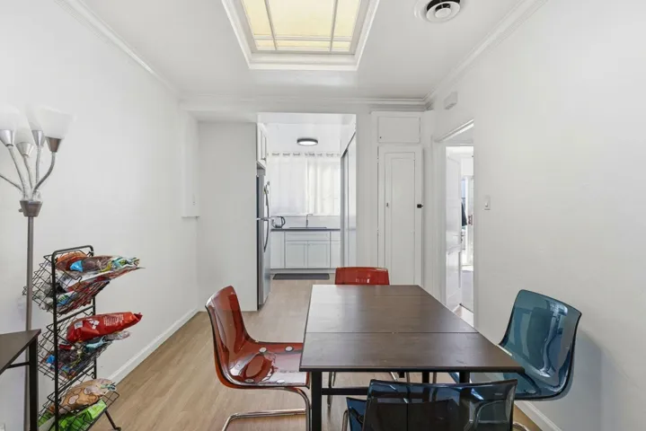 Dining area with light wood-type flooring and crown molding