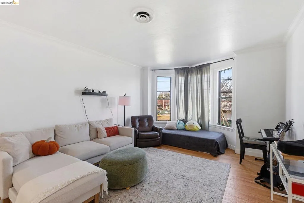 Living area featuring light wood finished floors and ornamental molding