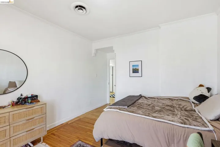 Bedroom featuring ornamental molding and wood finished floors