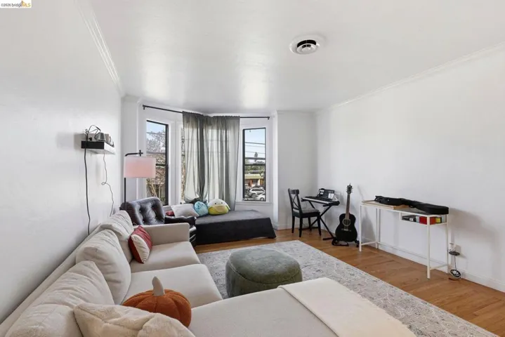 Living room with wood finished floors and crown molding