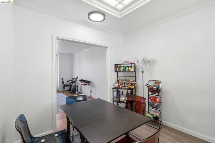 Dining room featuring wood finished floors, a desk, and crown molding