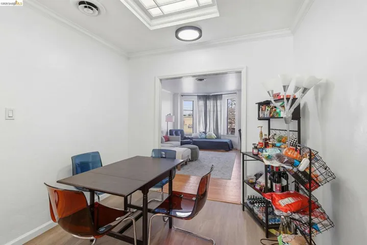 Dining area with light wood-style floors and crown molding