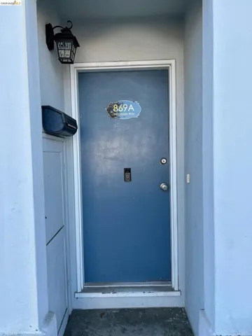 Doorway to property featuring stucco siding