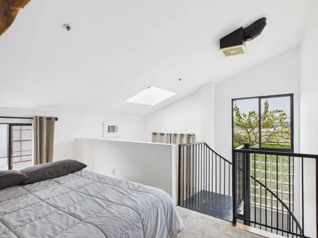 Bedroom with a skylight, multiple windows, and vaulted ceiling