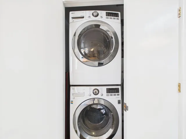 Washroom featuring stacked washer and clothes dryer