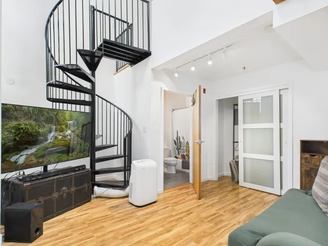 Staircase featuring wood finished floors and track lighting